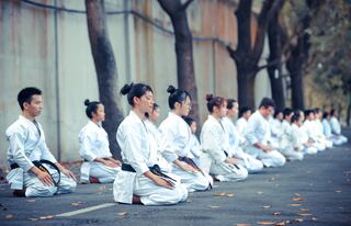 group of martial artists sitting on the ground by Thao Le Hoang